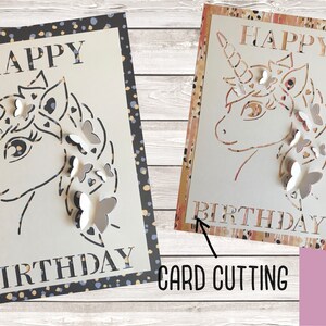 May include: A white card with a black and gold polka dot border. The card features a cut-out design of a unicorn with butterflies. The text "Happy Birthday" is written on the card.