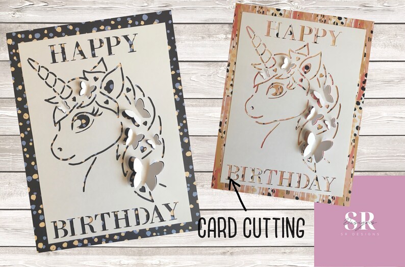 May include: A white card with a black and gold polka dot border. The card features a cut-out design of a unicorn with butterflies. The text "Happy Birthday" is written on the card.