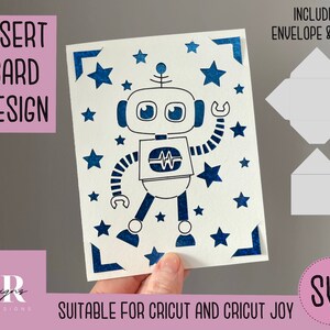 Könnte beinhalten: Ein blauer und weißer Roboter mit Sternen auf einer weißen Karte. Die Karte ist für Cricut und Cricut Joy geeignet. Das Bild enthält einen Umschlag und einen Futter.