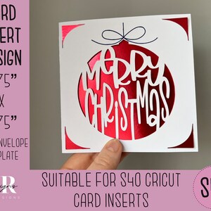 Può includere: Un biglietto bianco con un design a forma di ornamento rosso. L'ornamento ha le parole "Merry Christmas" tagliate. Il biglietto misura 4,75 pollici per 4,75 pollici.