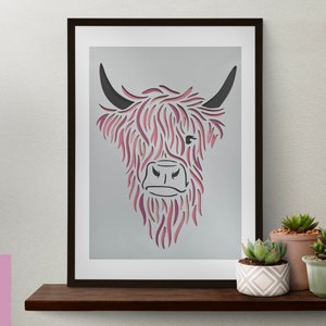 Puede incluir: Una ilustraci&oacute;n enmarcada de una vaca de las Tierras Altas con un degradado rosa y morado. La cabeza de la vaca est&aacute; mirando hacia adelante con los cuernos apuntando hacia arriba. El fondo es gris claro.