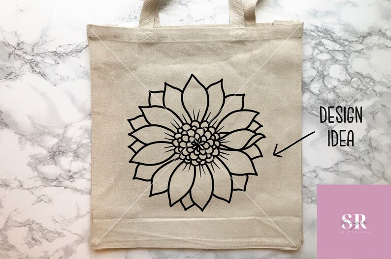 May include: A white tote bag with a black outline of a sunflower design. The text "DESIGN IDEA" is written on the right side of the bag.
