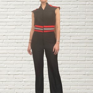 K&ouml;nnte beinhalten: Ein schwarzer Jumpsuit mit einem roten und grauen G&uuml;rtel. Der Jumpsuit ist &auml;rmellos und hat einen Rei&szlig;verschluss.