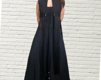 Könnte beinhalten: Ein schwarzer ärmelloser Jumpsuit mit einem langen Fransenbesatz am Saum. Der Jumpsuit hat einen V-Ausschnitt und einen taillierten Oberkörper.