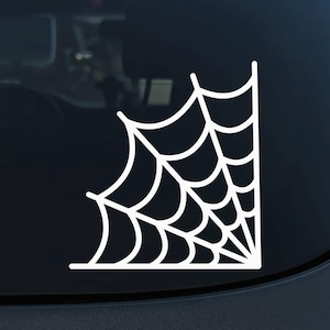 May include: White vinyl sticker of a spider web in the corner of a car window.