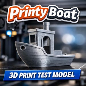 May include: A grey 3D-printed model boat with the text "PrintyBoat" in orange and white above it. The boat features a cabin, a smokestack, and the text "3D PRINT TEST MODEL" in a blue banner below.