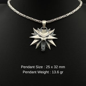 May include: Silver pendant necklace featuring a stylized wolf head design. The pendant is 25 x 32 mm and weighs 13.6 grams. The necklace has a detailed chain. The pendant is suspended from a silver chain. The text on the image reads: Pendant Size: 25 x 32 mm, Pendant Weight: 13.6 gr.