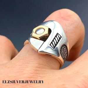 Peut inclure: Bague en argent avec un design de clé à molette, ornée d'un détail en forme d'écrou doré. La bague présente une texture détaillée et le texte "ELZSILVERJEWELRY" est visible en bas. Un bijou unique.