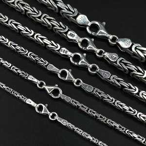 May include: A set of six silver chains with a box chain design. The chains are of varying lengths and are marked with the number "925" indicating they are made of sterling silver.