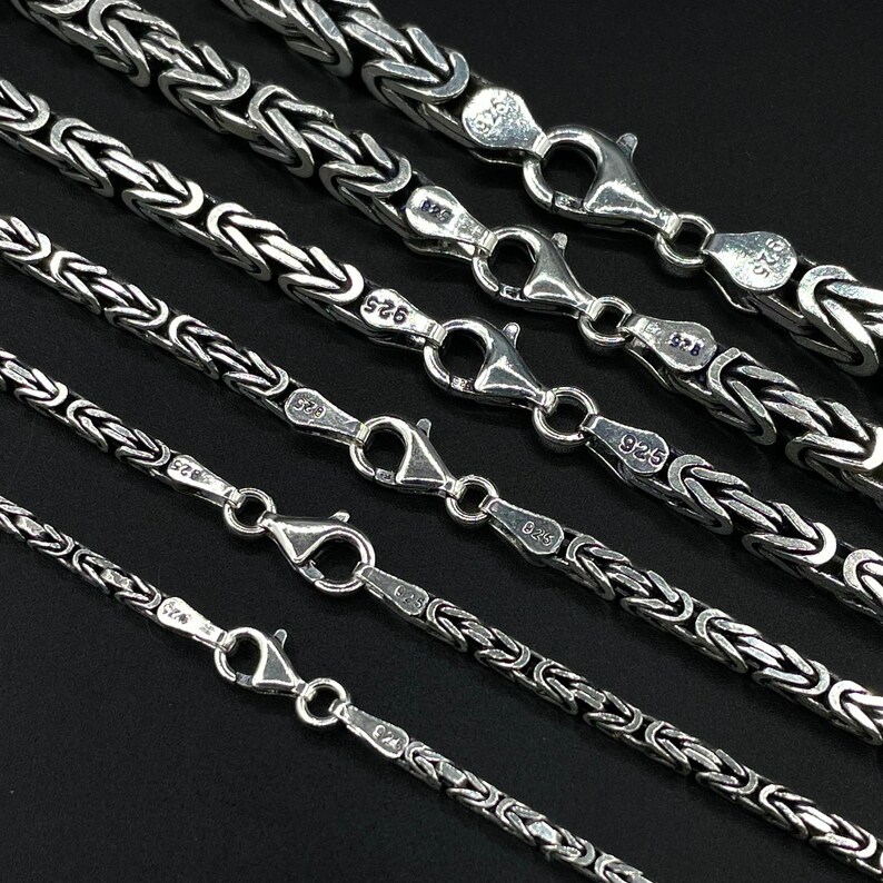 May include: A set of six silver chains with a box chain design. The chains are of varying lengths and are marked with the number "925" indicating they are made of sterling silver.