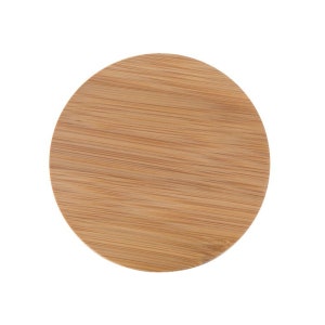 May include: A round, natural wood coaster made of bamboo. The coaster has a smooth, light brown surface with a wood grain pattern.