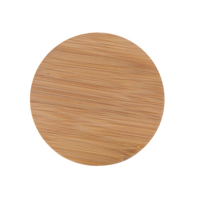 May include: A round, natural wood coaster made of bamboo. The coaster has a smooth, light brown surface with a wood grain pattern.