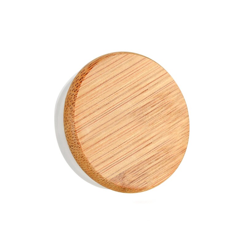 May include: A round, wooden lid with a natural wood grain finish. The lid is made of bamboo and has a white underside.