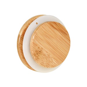 May include: A round, wooden lid with a white silicone seal. The lid has a small hole in the center.