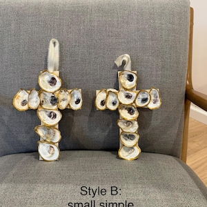 May include: Two cross-shaped wall ornaments decorated with iridescent oyster shells featuring gold-painted edges. Each cross includes a white ribbon loop at the top for hanging. The text "Style B: small simple" is printed at the bottom of the image.