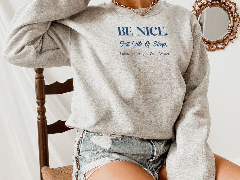 May include: A gray sweatshirt with the text "BE NICE. Get Lots Of Sleep. Drink Plenty Of Water." printed in blue.