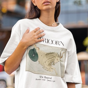 May include: White t-shirt with a vintage illustration of the Capricorn constellation and the text "The Reserved - December 22nd - January 19th" printed on the front.