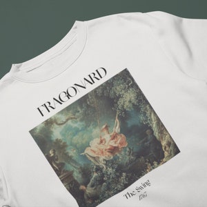 May include: White sweatshirt with a print of a painting by Jean-Honor&eacute; Fragonard titled "The Swing" from 1767. The painting depicts a woman on a swing in a lush garden setting.