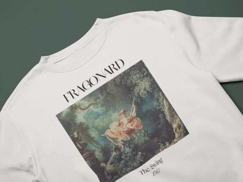 May include: White sweatshirt with a print of a painting by Jean-Honor&eacute; Fragonard titled "The Swing" from 1767. The painting depicts a woman on a swing in a lush garden setting.