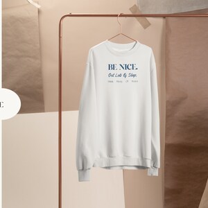May include: White crewneck sweatshirt with the text "BE NICE. Get Lots of Sleep. Drink Plenty of Water." printed in blue.