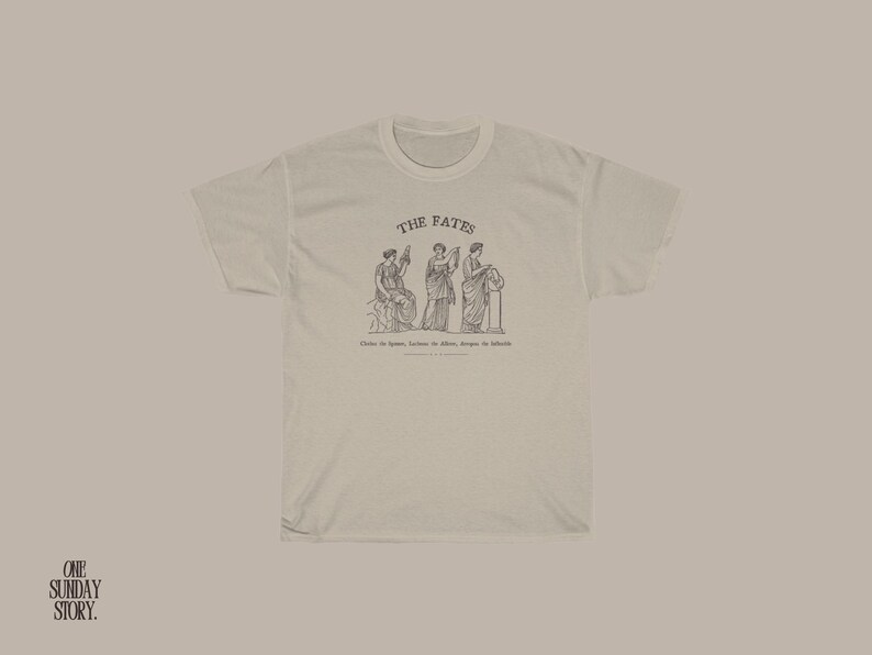 May include: A white t-shirt with a graphic of three women representing the Fates, with the text "THE FATES" above the image and "Clotho the spinner, Lachesis the allotter, Atropos the inflexible" below the image.
