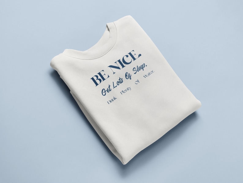 May include: A white sweatshirt with the text "BE NICE. Get Lots Of Sleep. Drink Plenty Of Water." printed in blue.
