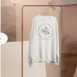 May include: White sweatshirt with a floral design and the text "Love is forever, doing can't expect you to love me, but you can expect me to love you. From the moment I met you, my heart knew, I had found my soul mate.  Forever yours,  Your Soul Mate"