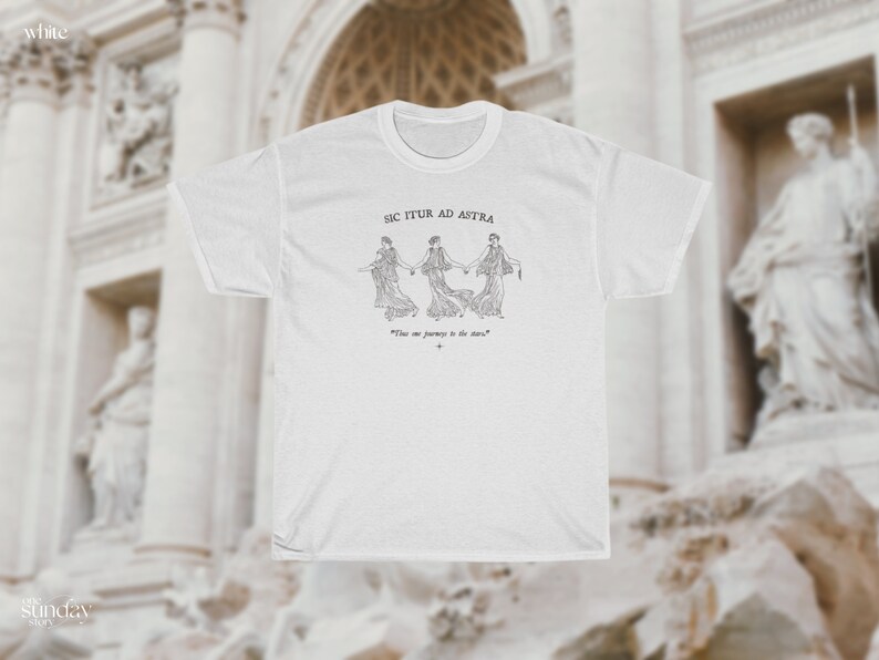 May include: White t-shirt with a black and white illustration of three women holding hands. The text "Sic Itur Ad Astra" is above the illustration and the text "This is our journey to the stars" is below the illustration.