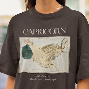 May include: Brown t-shirt with a vintage illustration of the Capricorn constellation and the text "CAPRICORN The Reserved December 22nd - January 19th"