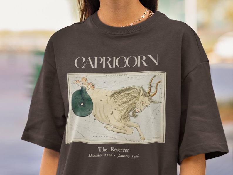 May include: Brown t-shirt with a vintage illustration of the Capricorn constellation and the text "CAPRICORN The Reserved December 22nd - January 19th"