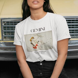 Pode incluir: Camiseta branca com um gr&aacute;fico da constela&ccedil;&atilde;o de G&ecirc;meos e o texto "GEMINI The Communicator May 21 - June 20"