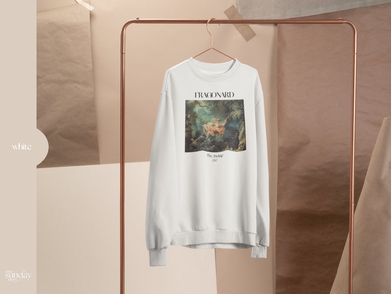 May include: White sweatshirt with a painting of a couple on a swing by Jean-Honor&eacute; Fragonard. The painting is titled "The Swing" and the year 1767 is printed below it.