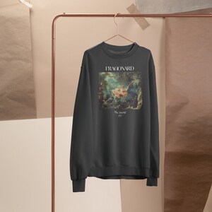 May include: A dark gray sweatshirt with a print of a painting by Fragonard. The painting depicts a woman in a white dress sitting on a swing. The text "The Swing" and "1767" are printed below the painting.