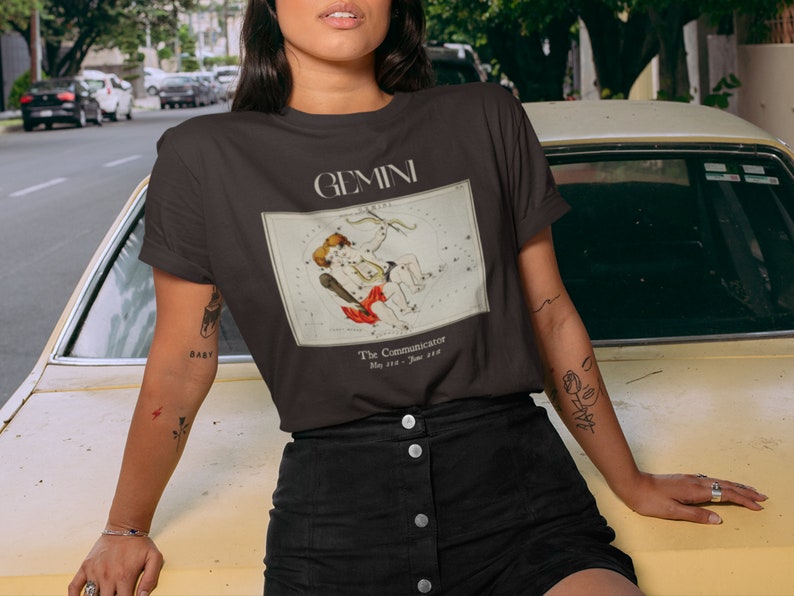 Pode incluir: Camiseta preta com um gr&aacute;fico da constela&ccedil;&atilde;o de G&ecirc;meos e o texto "GEMINI The Communicator May 21st - June 21st"