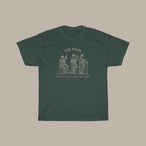 May include: A dark green t-shirt with a white graphic of three figures labeled "The Fates". The text below the figures reads "Clotho, the spinner, Lachesis, the allotter, Atropos, the inevitable".