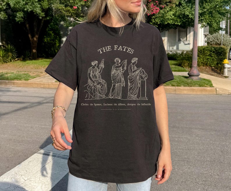 May include: Black t-shirt with a white graphic of three figures labeled "The Fates" and the text "Clotho the Spinner, Lachesis the Allotter, Atropos the Inevitable."