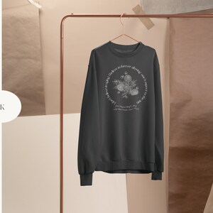 May include: Black sweatshirt with a white floral design and the text "Love like forever, always, over and over again.  Joy Blooms Wild, 2019."