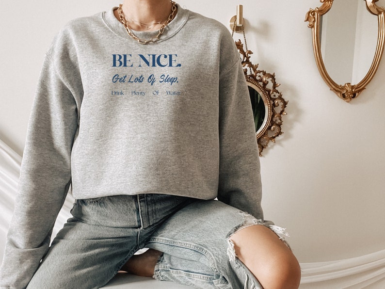 May include: A gray sweatshirt with the text "BE NICE. Get Lots Of Sleep. Drink Plenty Of Water." printed in blue.