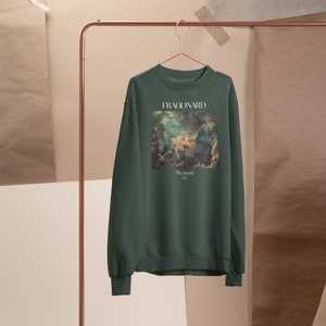 May include: Forest green sweatshirt with a painting of a woman in a boat on the front. The painting is titled "The Swing" by Fragonard.