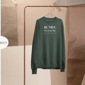 May include: Forest green sweatshirt with the text "BE NICE. Get Lots of Sleep. Drink. Play. Or Dance." in white.
