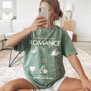 May include: A green t-shirt with the text "Hot Girls Read Romance" and a graphic of nine squares with different images. The text "A Book Club by Booked Reader Girls" is at the bottom of the shirt.