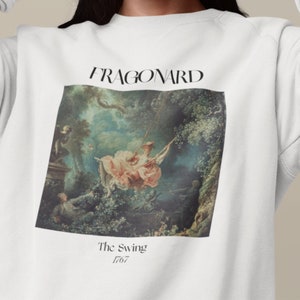 May include: White sweatshirt with a print of a painting by Jean-Honor&eacute; Fragonard called "The Swing" from 1767. The painting depicts a woman on a swing in a lush garden setting.
