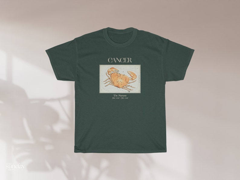 May include: A dark green t-shirt with a vintage illustration of the Cancer zodiac sign, a crab, and the text "Cancer, The  Nurturer, June 21st - July 22nd".