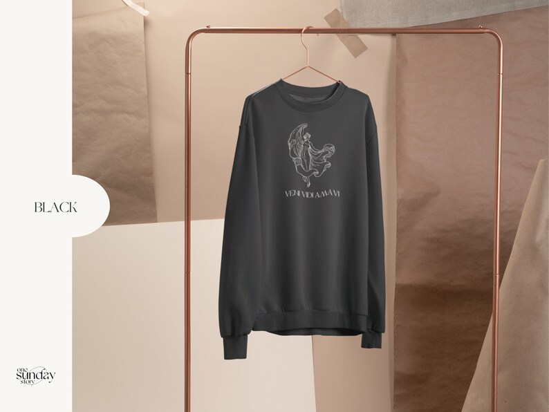 May include: Black sweatshirt with a white graphic of a woman dancing in front of a crescent moon. The text "VERIDICA AMAVI" is printed below the graphic.
