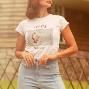 Pode incluir: Uma camiseta branca com um gr&aacute;fico da constela&ccedil;&atilde;o de G&ecirc;meos e o texto "GEMINI The Communication May 21 - Jun 21".