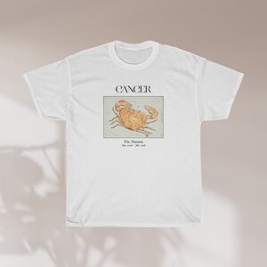May include: White t-shirt with a graphic of a crab and the text "CANCER The  Numinous June 21st - July 22nd"