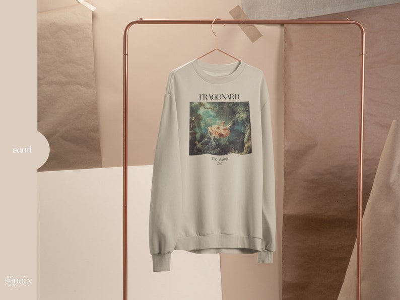 May include: A beige sweatshirt with a print of a painting by Fragonard, "The Swing", on the front. The text "FRAGONARD" and "The Swing 1767" is printed below the image.