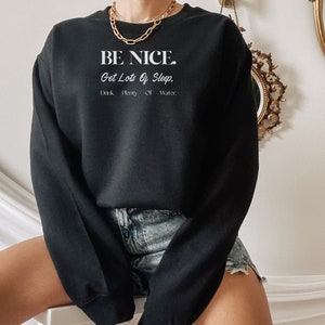 May include: Black sweatshirt with the text "BE NICE. Get Lots Of Sleep. Drink Plenty Of Water." in white lettering.