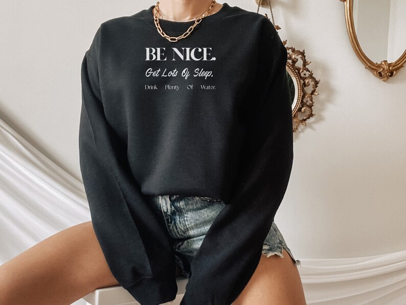 May include: Black sweatshirt with the text "BE NICE. Get Lots Of Sleep. Drink Plenty Of Water." in white lettering.