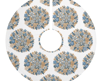 May include: A circular white tree skirt featuring a repeating pattern of round ornaments composed of blue and gold snowflakes, pine needles, and small berries. The fabric has a central circular cutout and a straight slit for placement.